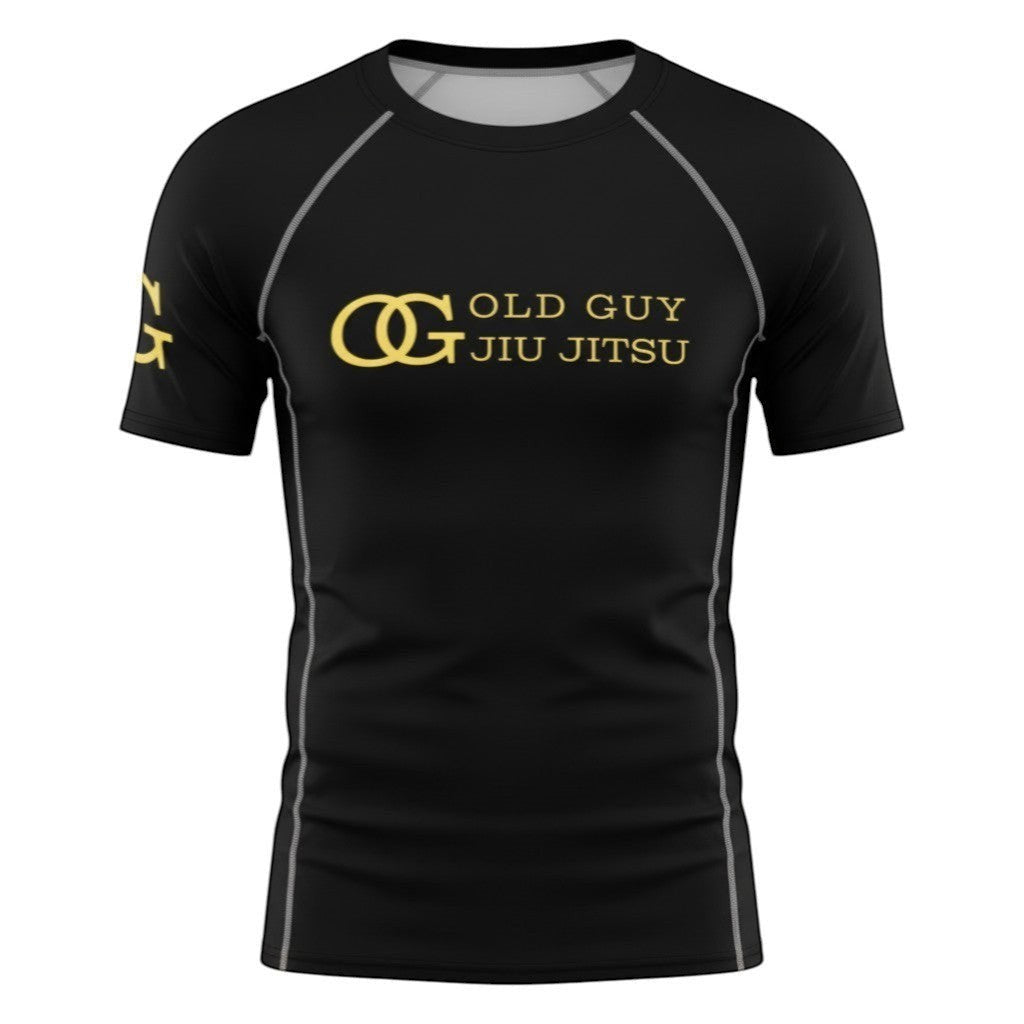 The Jawn Jitsu Shop black short sleeve rash guard with gold OG Old Guy Jiu Jitsu logo and graphic on sleeve.